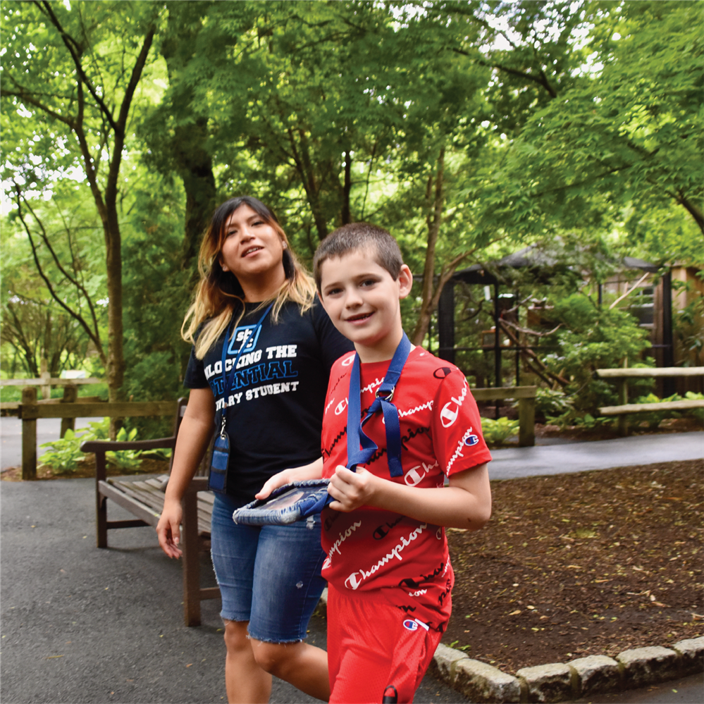 Student walking with paraprofessional at the Bergen County Zoo.